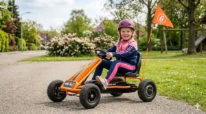An orange electric go-kart for 6 year olds with adjustable seating and safety flags.