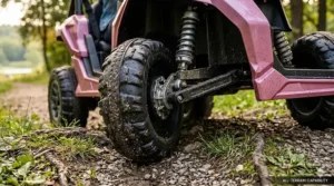 Illustration of heavy-duty traction tires on a pink 24V ride-on toy navigating grass and gravel.