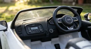 Detailed interior view of an Audi R8 ride on car for toddlers showing steering wheel buttons and MP3 audio console