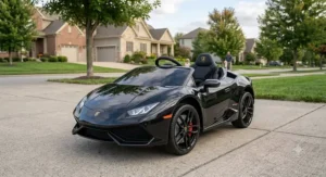 A sleek black 12V Lamborghini Huracan motorized ride-on car for kids parked on an outdoor pavement.