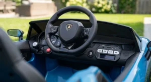 Close-up view of the interior dashboard, steering wheel, and MP3 music buttons of a motorized Lamborghini ride-on car for kids.