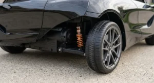 Close-up of the spring suspension and wear-resistant wheels on a McLaren 12V electric ride-on car