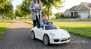 A white Porsche 911 ride on toy push car configuration with an adjustable parent handle for neighborhood walks.