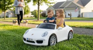 Two children playing together in a premium two-seater style Porsche 911 ride on toy parked on a green lawn.