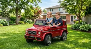 Two children sitting in a 24V two-seater Mercedes-Benz G-Wagon ride-on car on a backyard lawn.