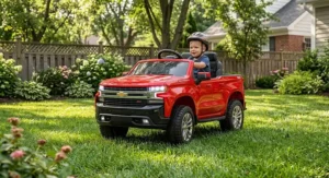 Child driving a 24V Chevy Silverado ride on truck across a grassy backyard lawn