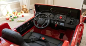 Detailed dashboard and safety seatbelt feature on a red electric fire engine ride-on vehicle for young kids.