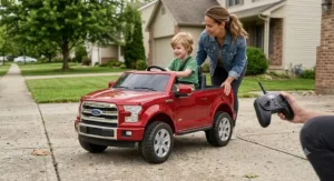 A parent holding the wireless parental remote control next to a kids Ford F150 ride on truck.