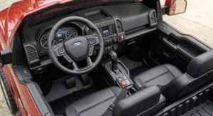 Interior dashboard and steering wheel of a two seater Ford F150 ride on truck for kids.