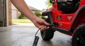 Demonstration of plugging in the charger to the rechargeable battery port on a 12V Jeep Wrangler ride-on car
