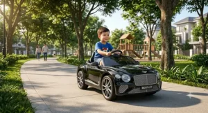 Little boy driving a black Bentley ride-on car on a paved sidewalk in a neighborhood park.