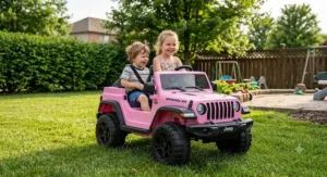 Two young children smiling while driving a pink 12V Jeep Wrangler ride-on toy car in a backyard