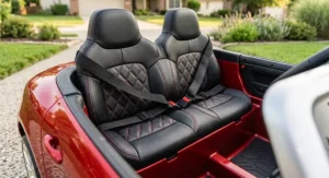 Interior detail view of premium leather seats and seatbelts inside a 2 seater luxury ride on car for toddlers