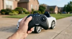 Hand holding a 2.4GHz wireless parent remote control for a toddler Bentley ride-on car.