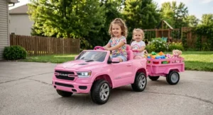 A pink Ram truck ride-on toy with a matching trailer designed for young girls playing outdoors.
