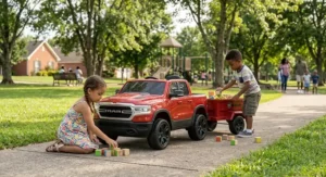 Two children playing outdoors next to a parked Ram truck ride on toy with trailer in a neighborhood park.