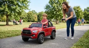 Parent holding a wireless remote control while guiding a toddler driving a licensed Toyota Tacoma ride-on car