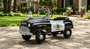 A retro-style pedal-powered ride on police car for kids with a classic silver bell on the front.