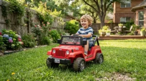 A toddler steering a motorized electric ride-on car on backyard grass.