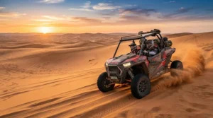 An off-road electric vehicle for teenagers cruising across an open desert landscape at sunset.