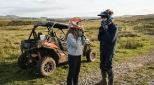 Teenagers putting on helmets and safety gear before riding their off-road electric vehicle for teenagers.