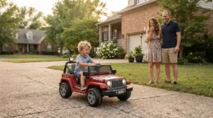 Parents watching their child pilot a ride-on car for preschooler with disability down a suburban driveway.