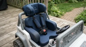 Custom postural inserts fitted inside a ride-on car for preschooler with disability on a patio.