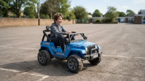 A joyful preteen driving a fast ride-on car for tall 12 year old on an open tarmac area