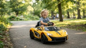 Happy child playing in a sleek yellow sports ride-on car for 3 year old on park pavement