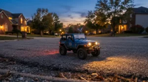 Bright LED headlights glowing on a 12v two seater ride on truck for two toddlers during late afternoon fun.