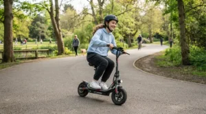 Teen riding an electric scooter alternative ride-on for teens along a paved community park trail