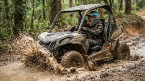 A rider wearing full safety gear operating an off-road electric vehicle for adults on a muddy course.