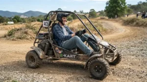 A tall driver comfortably testing an off-road electric vehicle for adults on a dirt track.