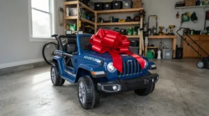 A large red bow tied onto a two seater ride on car for Christmas gift in a suburban garage